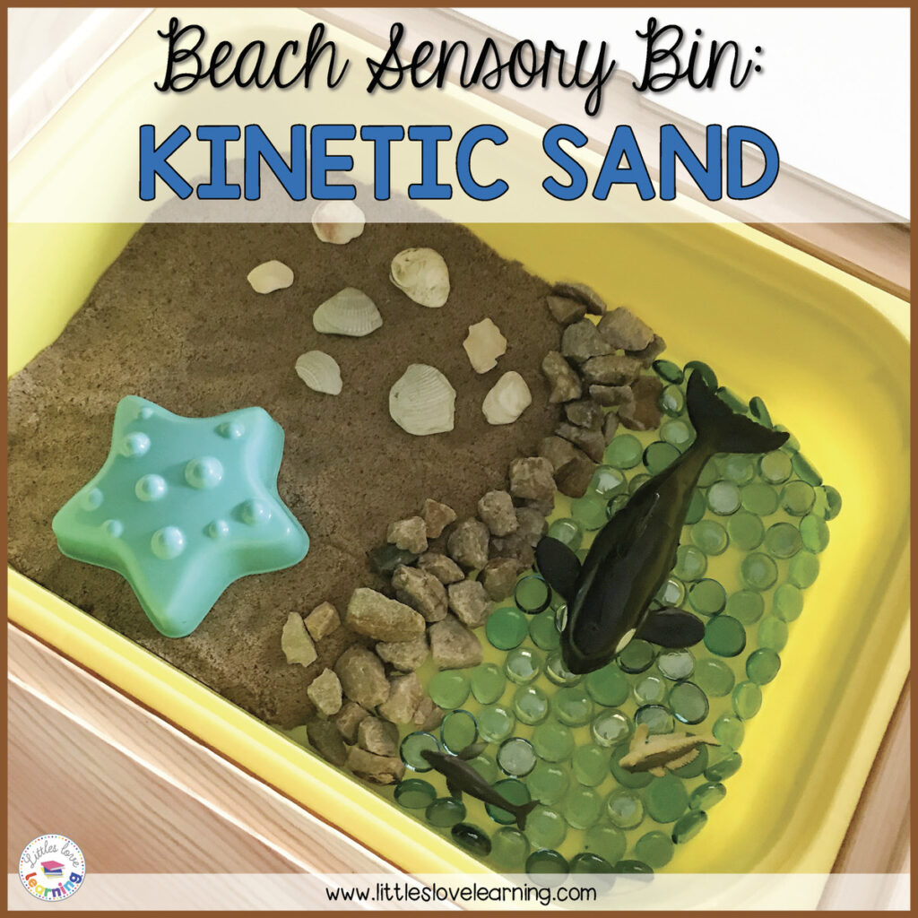 Preschool beach sensory bin with kinetic sand, seashells, blue gems, and sea animals.
